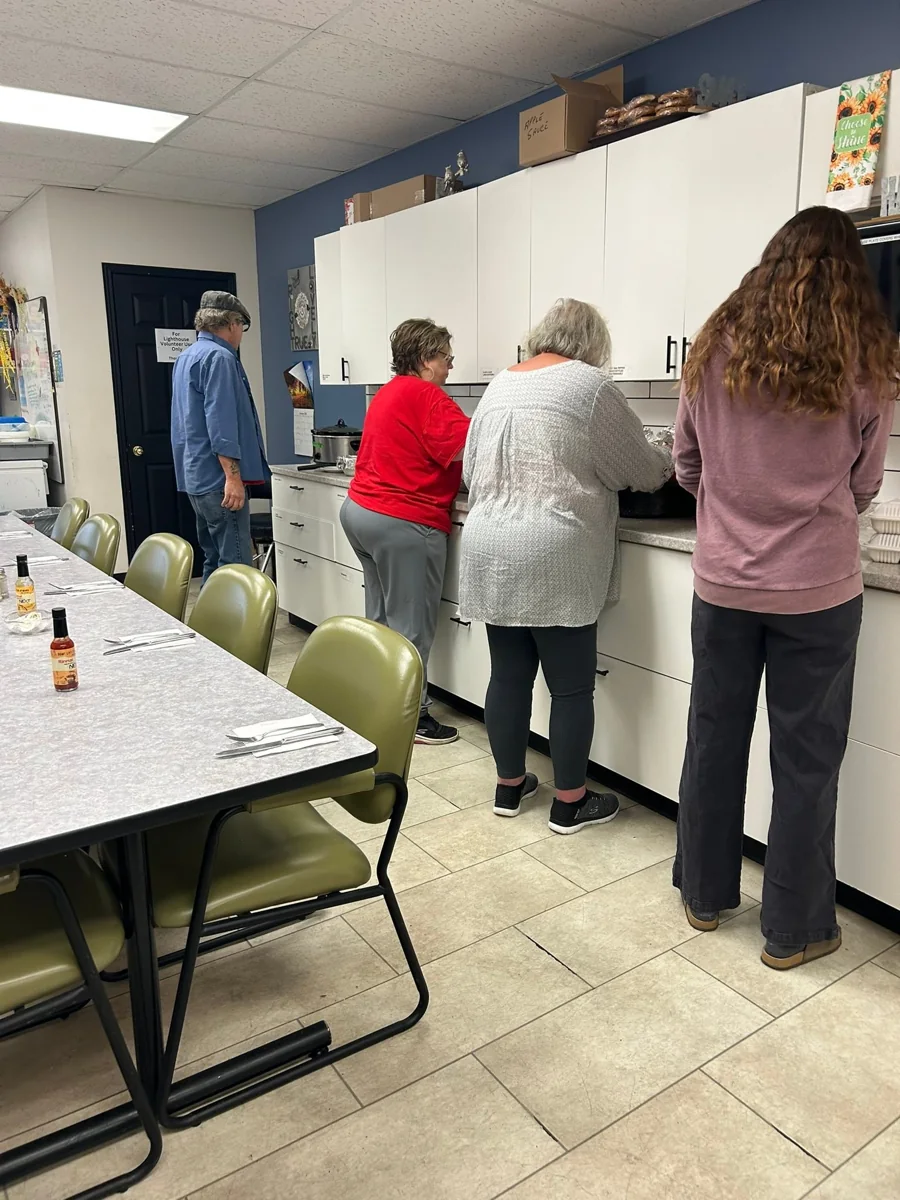 Volunteers preparing and packing food in a community kitchen